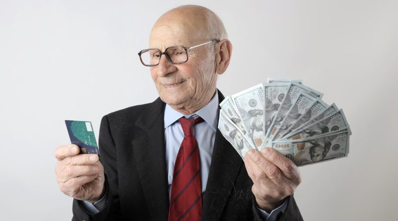 man in black suit holding banknotes and credit card
