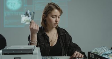 a woman sitting at a table accounting a sum of cash